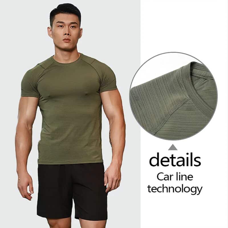 Confident man in olive-green athletic shirt & black shorts showcasing modern fitness style.