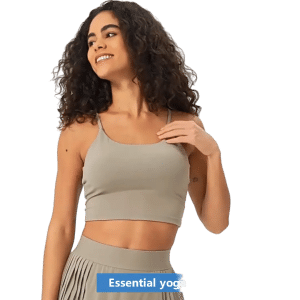 Cheerful woman in beige yoga wear showcasing confidence and comfort against a green background.